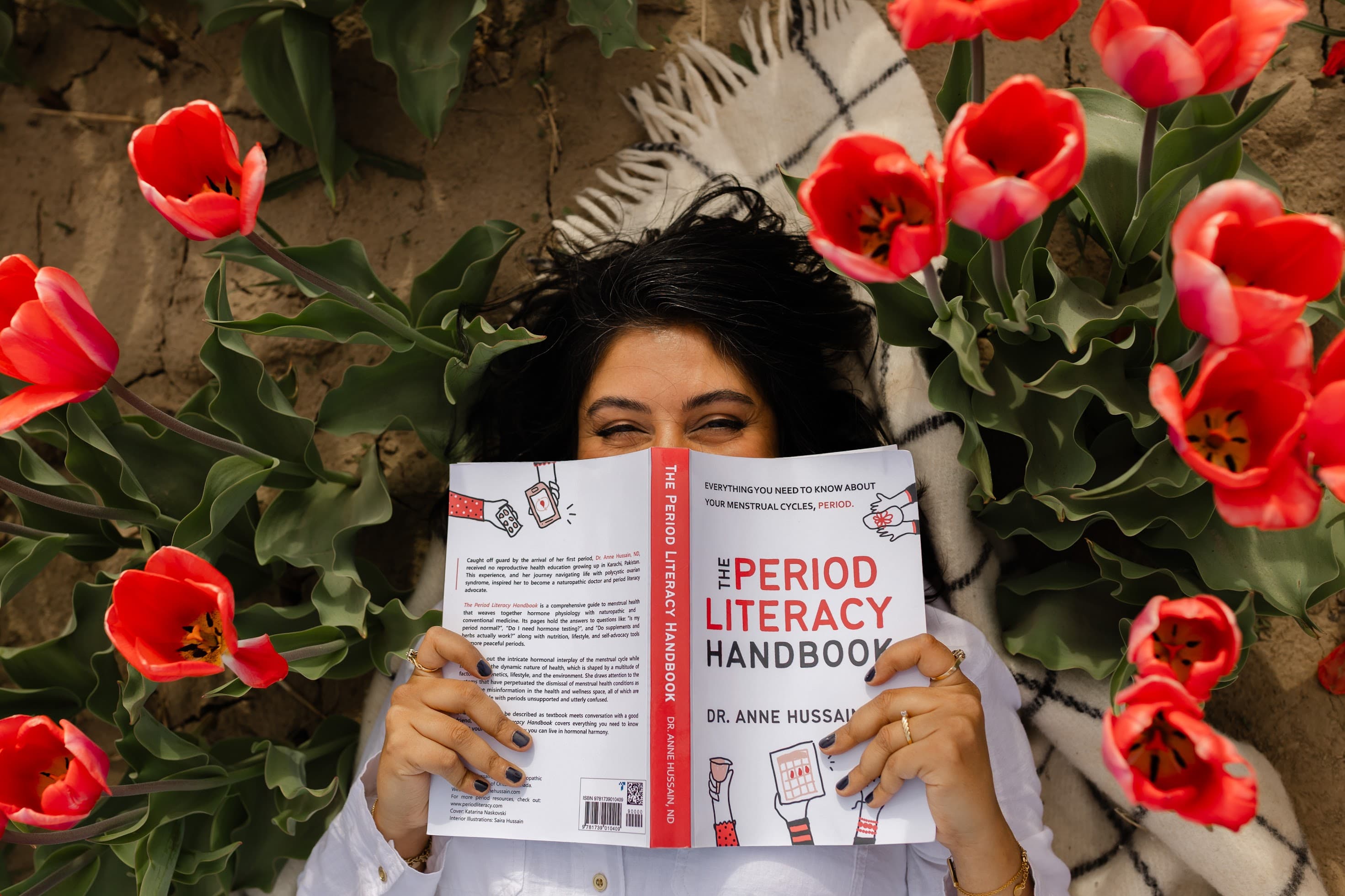 Dr. Anne Hussain holding The Period Literacy Handbook